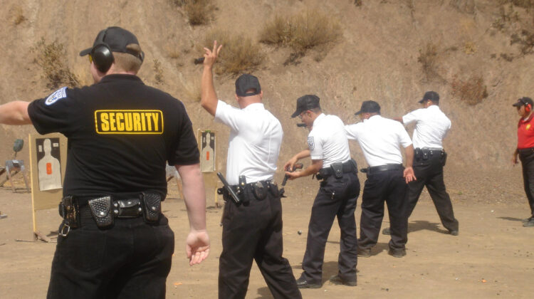 A group of police officers lined up, engaged in Professional Unarmed Guard Training.